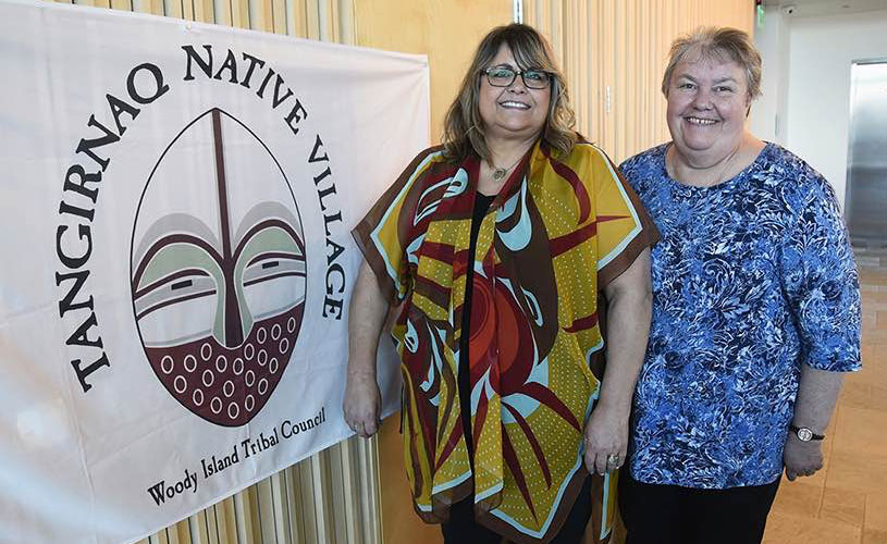 Two women next to Tangirnaq flag